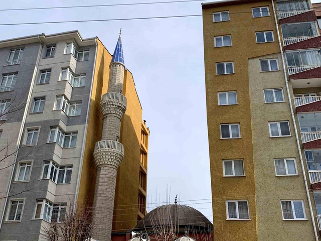 İki apartmanın arasında sıkışıp kalan cami, ilginç görüntüsüyle dikkat çekiyor