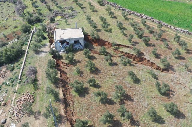 Deprem bölgesindeki bir ev, arazide oluşan yarığa gömüldü