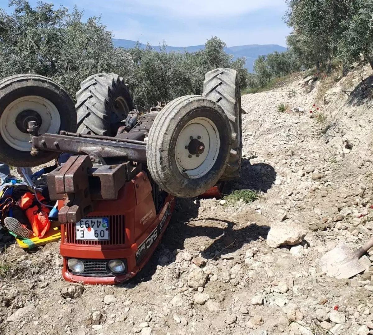 Devrilen traktörün altından yardım istedi
