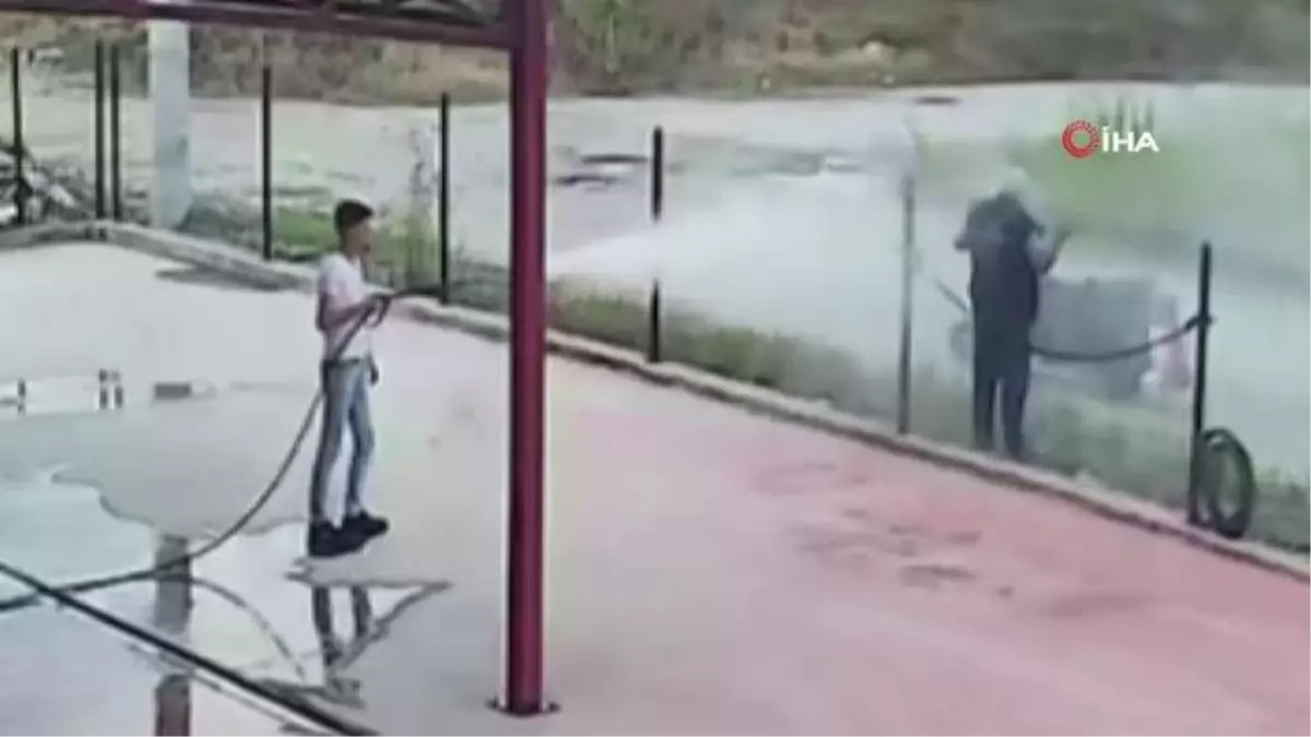 Sıcaktan bunalan adam oto yıkamacıda serinledi