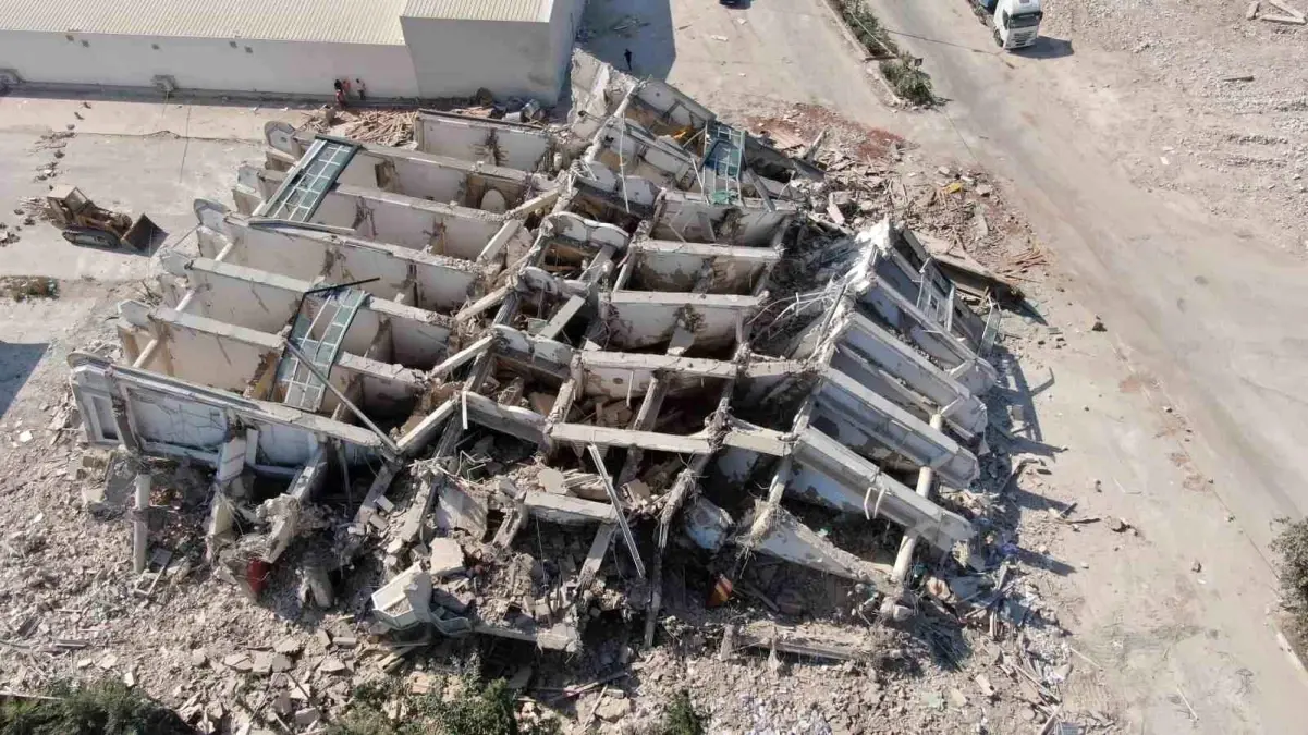 Depremin vurduğu Hatay\'da iş makinesinin üzerine çökerek operatöre mezar olan 8 katlı bina dronla görüntülendi