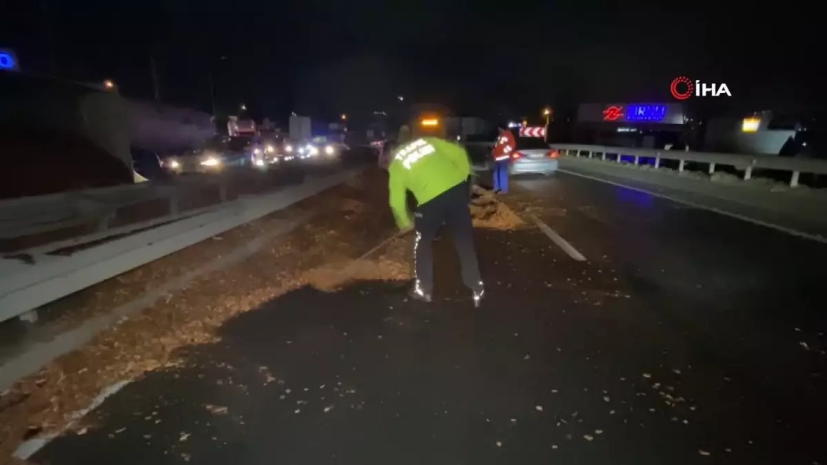 Polis eline aldığı fırçayla devrilen tırdan yola dökülen talaşı temizledi