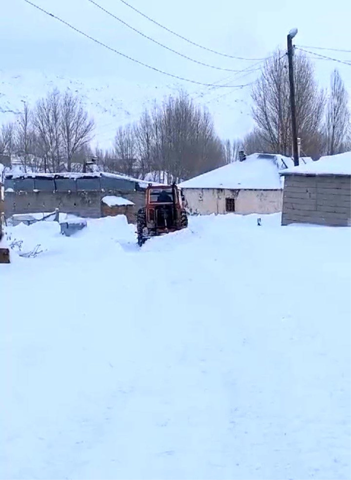 Van\'ın Özalp ilçesinde muhtar, traktörüne monte ettiği kar küreme aparatıyla mahallenin yollarını açıyor