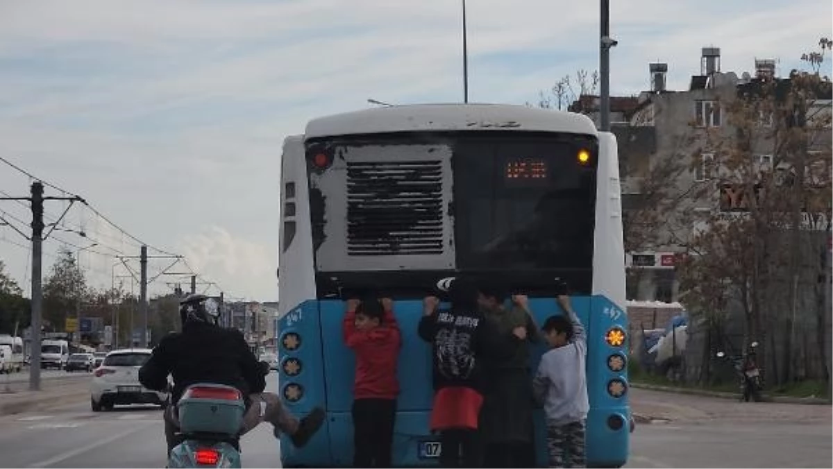 Antalya\'da Patenli Çocuklar Belediye Otobüsünün Arkasına Tutunarak Yolculuk Yaptı
