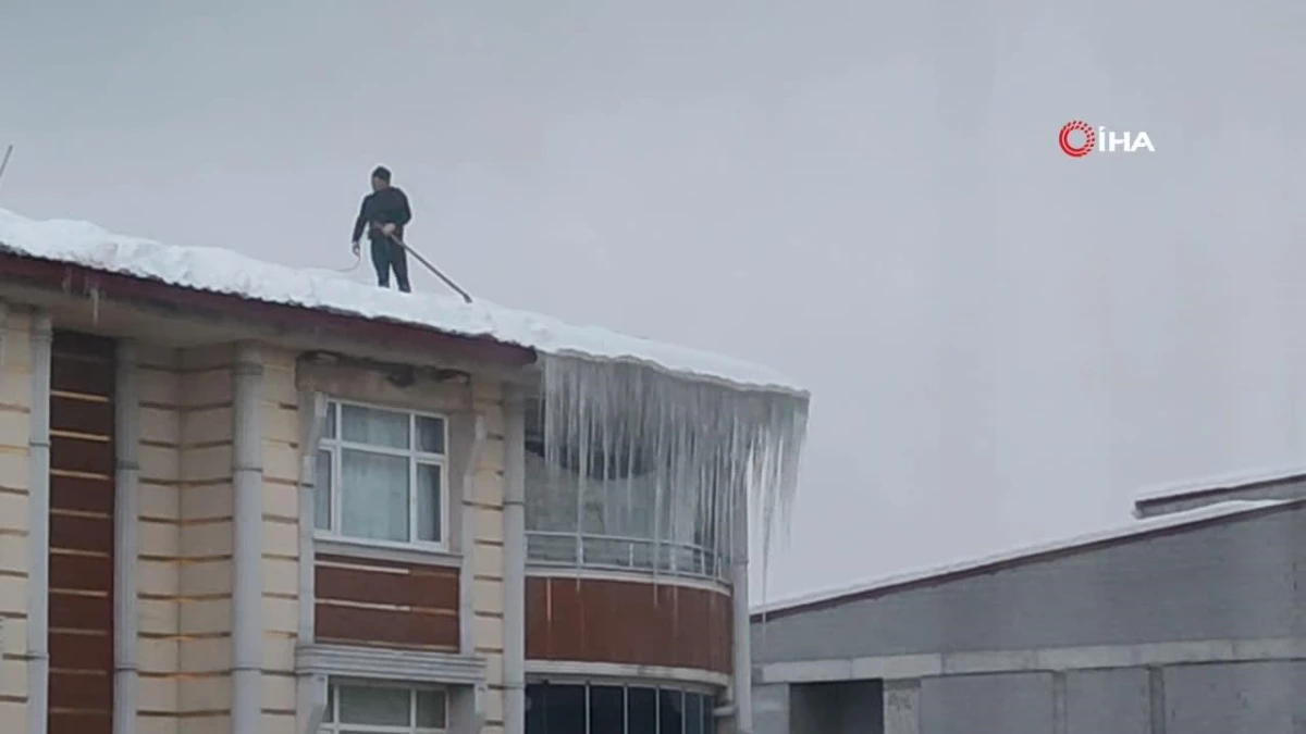 İpin ucundaki hayat: Beline bağladığı iple tehlikeye aldırış etmeden çatıda biriken kar yığınını temizledi