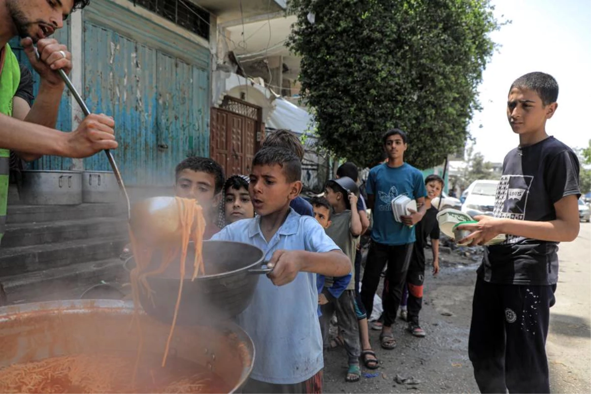 Gazze Şeridi\'nde İsrail saldırıları devam ederken yardım kuruluşları çocuklara sıcak yemek dağıtıyor