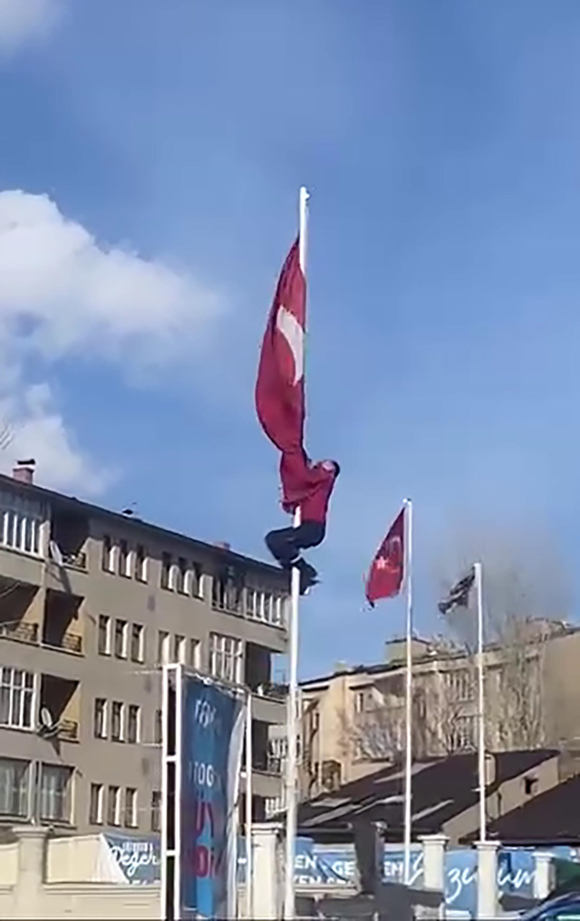 Rüzgarda dolanan bayrağı düzeltmek için 15 metrelik direğe tırmandı