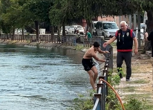 Tehlikeye aldırmadan kanalda serinleyen çocukları polis çıkardı, ailelerine ceza yazdı
