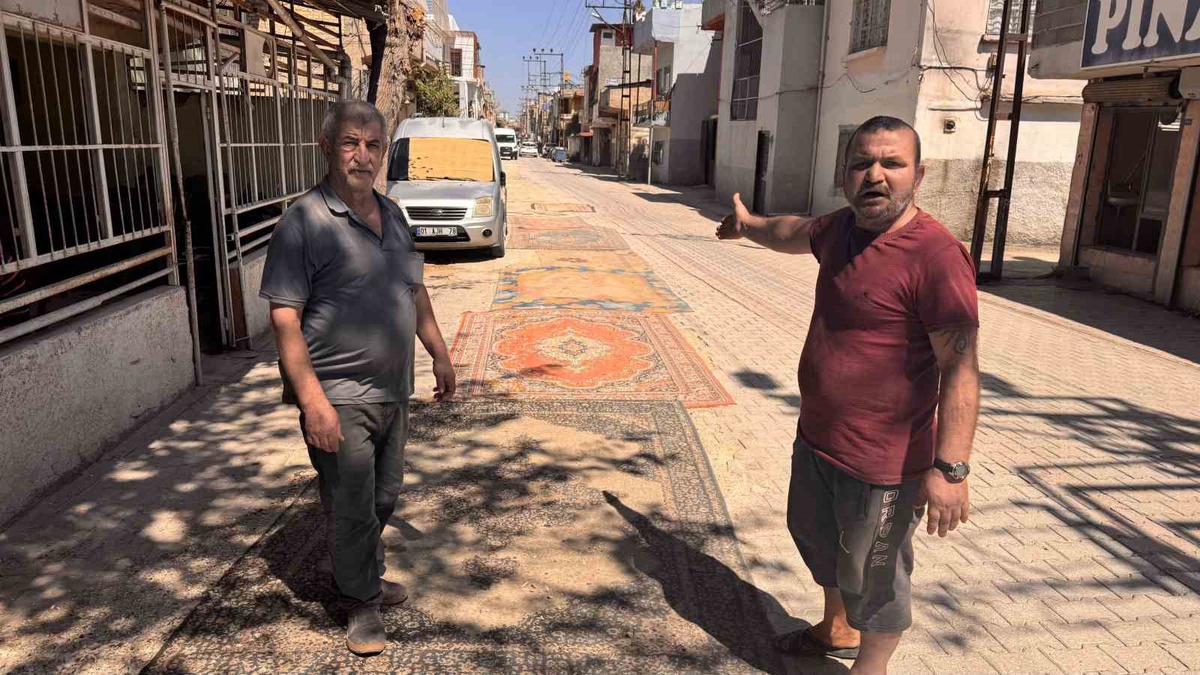 Tozdan bunalan mahalleli çareyi sokağa halı sermekte buldu