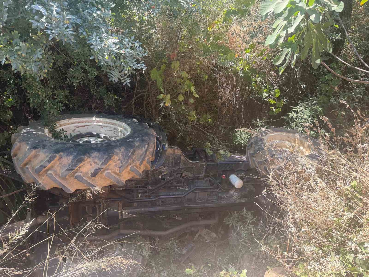 Devrilen traktörün altındaki sürücüyü itfaiye ekipleri kurtardı