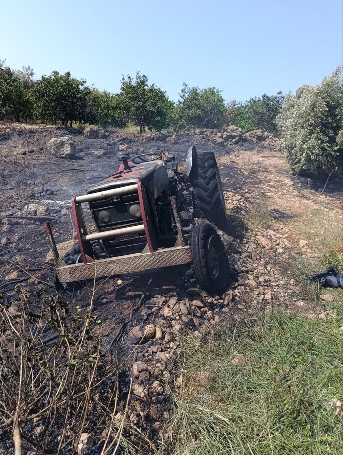 Hatay'ın Erzin ilçesinde otluk alanda çıkan yangında park halindeki traktör hasar gördü