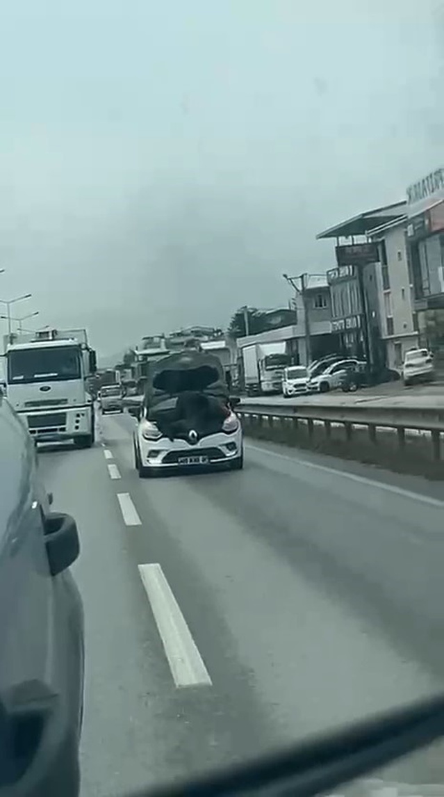 Bursa'da hareket halindeki otomobilin kaputunda tamirat yapan tamirci şaşkınlık yarattı