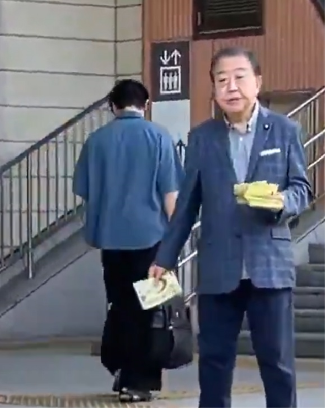 Japonya'nın eski başbakanı sokakta broşür dağıtırken görüntülendi