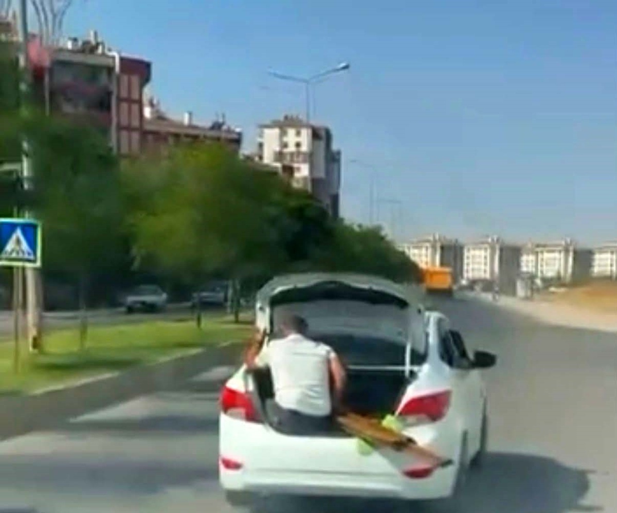 Diyarbakır\'da bagaj kapısında oturan çocuk ve malzeme taşıyan kişi görüntülendi