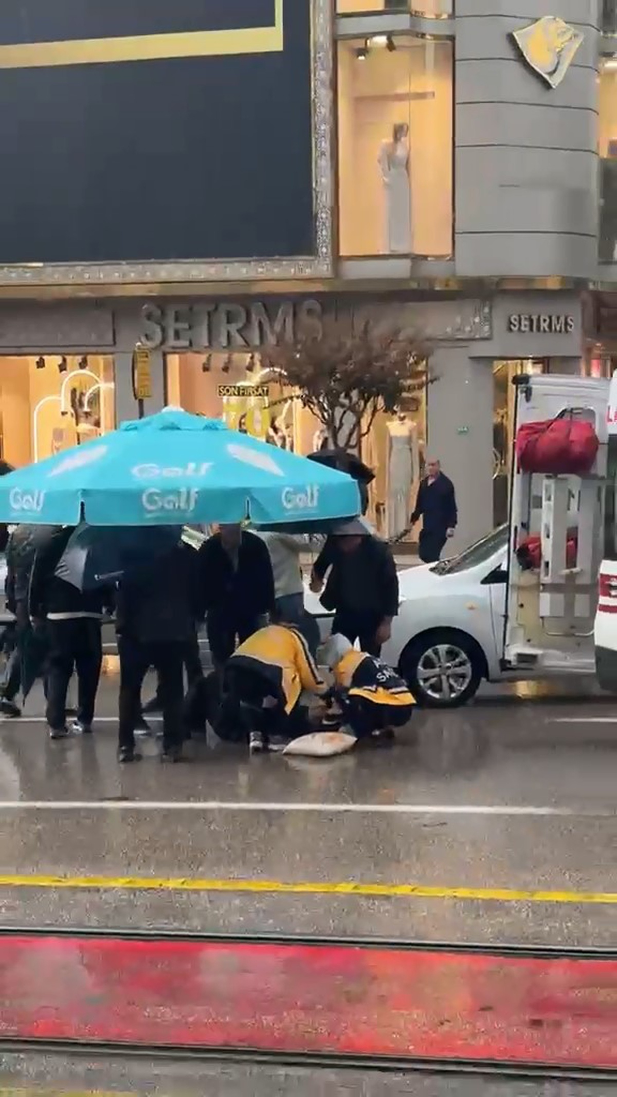 Bursa Osmangazi\'de otomobil yayaya çarptı, çevredekiler yağmurda şemsiye tuttu