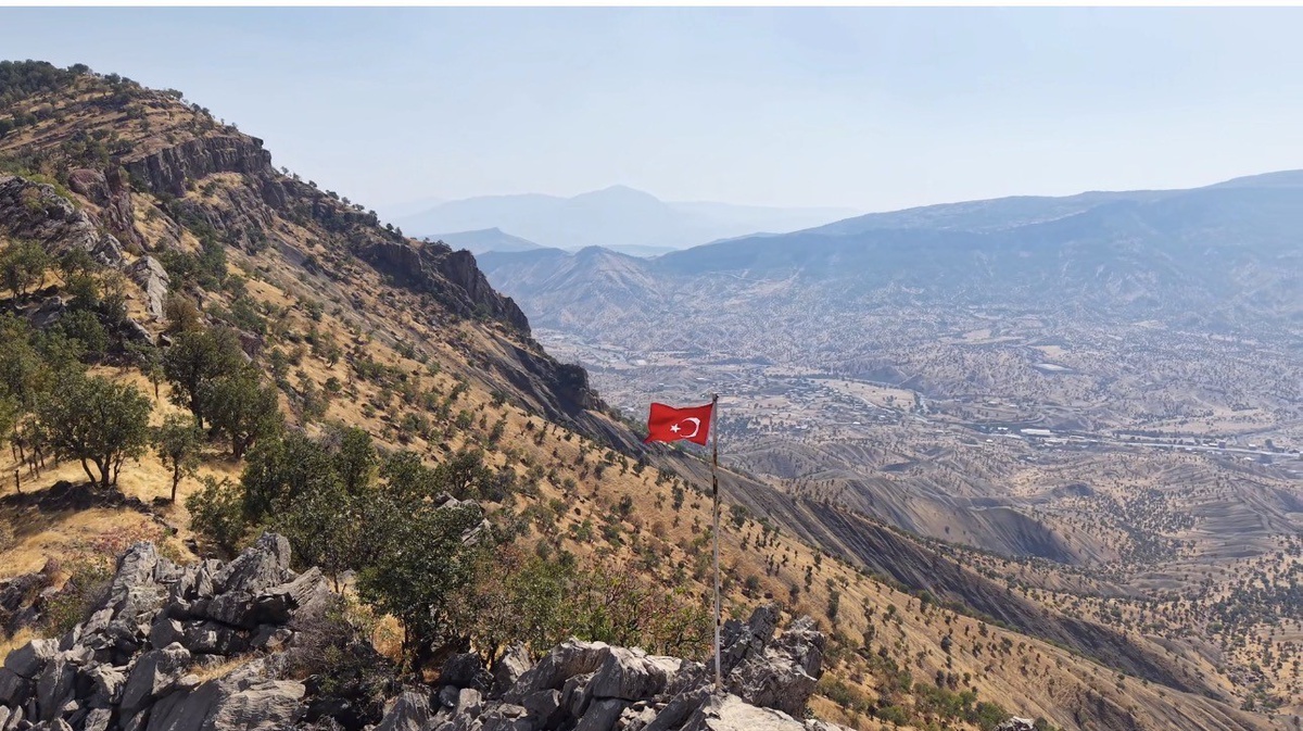 Hakkari Derecik Aydınlık köyünde yıpranan Türk bayrağını gazeteci öperek yeniledi