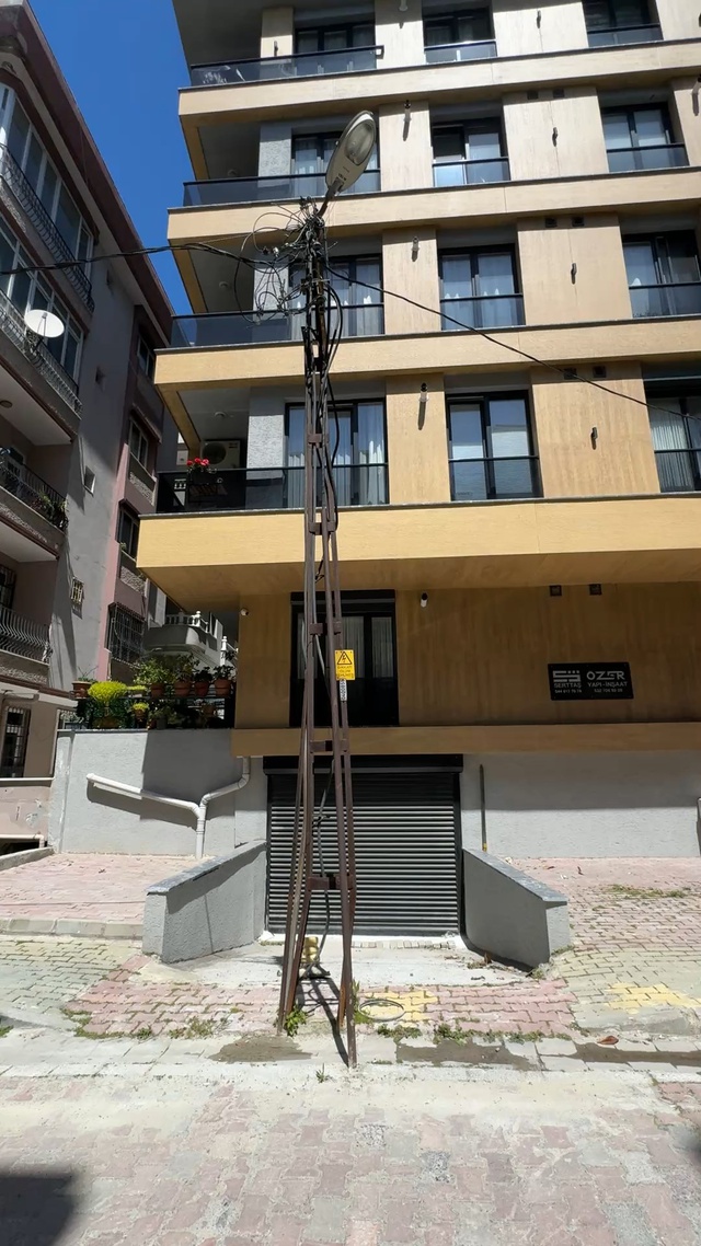 Binayı inşa ettiler, elektrik direğini hesaba katmadılar! Şimdi ise araçları sokağa park ediyorlar