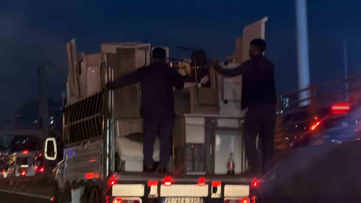 Diyarbakır\'da eşyalar düşmesin diye kamyonet kasasına tutunan iki kişi görüntülendi