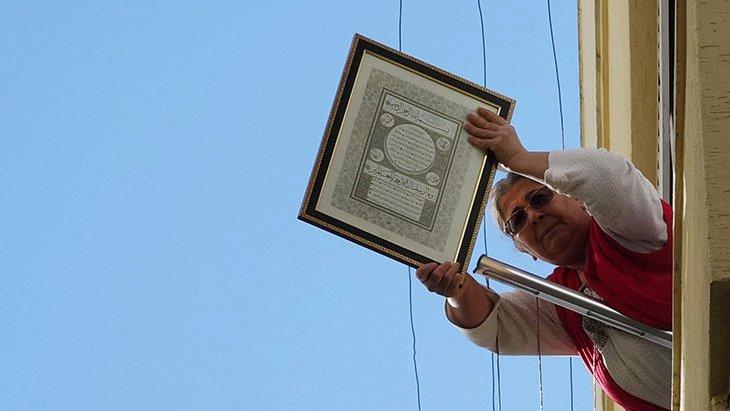 Yangın çıkan dairenin alt katında oturan kadın, itfaiyecilere balkondan ayet tutarak destek verdi